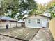 Fenced backyard with wooden deck, grass, and mature trees at 4114 E Sewaha St, Tampa, FL 33617