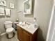 Functional bathroom featuring a toilet, sink, mirror and necessary storage for toiletries and personal items at 4114 E Sewaha St, Tampa, FL 33617