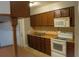 Well-equipped kitchen with brown cabinets, white appliances, and a breakfast bar with modern amenities at 4114 E Sewaha St, Tampa, FL 33617