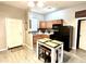 Open kitchen featuring tile floors, stainless steel appliances and a modern white table at 4114 E Sewaha St, Tampa, FL 33617