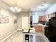 Kitchen with stainless steel appliances, tile floors, a modern light fixture and a white table at 4114 E Sewaha St, Tampa, FL 33617