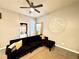 Cozy living room featuring tile floors, ceiling fan and a modern black sofa at 4114 E Sewaha St, Tampa, FL 33617