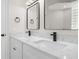 Bathroom featuring double vanity with stone countertop, modern faucets, and glass block window at 4317 74Th E Ave, Sarasota, FL 34243