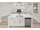 Open concept kitchen island with sink, stainless steel dishwasher, and view of fireplace at 4317 74Th E Ave, Sarasota, FL 34243