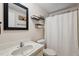 Bathroom with a white sink, black framed mirror, toilet, shower, and some shelves at 4801 Blanco Dr, Zephyrhills, FL 33541