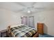 Bright bedroom with a bed featuring patterned covers, ceiling fan, and a well-lit ambiance for a cozy feel at 4801 Blanco Dr, Zephyrhills, FL 33541