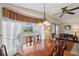 Elegant dining room with hardwood table, decorative curtains, and ample natural light at 4801 Blanco Dr, Zephyrhills, FL 33541