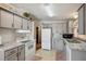 Well-lit kitchen with gray cabinets, white appliances, and charming decor, perfect for cooking at 4801 Blanco Dr, Zephyrhills, FL 33541