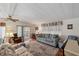 Bright living room with hardwood floors, a ceiling fan, and access to an outdoor patio at 4801 Blanco Dr, Zephyrhills, FL 33541