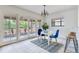 Bright breakfast nook with modern chandelier, blue chairs, walkout to deck and view of the landscaped yard at 4802 W Dryad St, Tampa, FL 33629