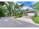 Charming tan home showcasing a two-car garage, mature trees, and inviting curb appeal at 4802 W Dryad St, Tampa, FL 33629