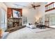 Living room featuring stone fireplace with wood mantle, vaulted ceiling, ceiling fan and plush carpet at 4802 W Dryad St, Tampa, FL 33629