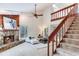 Open living room featuring stone fireplace, wood paneling, vaulted ceiling and staircase with wood accents at 4802 W Dryad St, Tampa, FL 33629