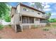 Large, tan home featuring a spacious screened porch, stairs, and mature landscaping at 4802 W Dryad St, Tampa, FL 33629