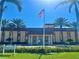 Inviting Resident's Club entrance framed by palm trees, lush landscaping, and a waving American flag at 4900 Brittany S Dr # 808, St Petersburg, FL 33715