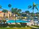 Community pool surrounded by manicured landscaping and tiki umbrellas for a relaxing tropical vibe at 4900 Brittany S Dr # 808, St Petersburg, FL 33715