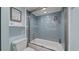 Updated bathroom with blue subway tile shower and sliding glass door at 500 Treasure Island Cswy # 704, Treasure Island, FL 33706