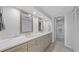 Bright bathroom featuring double vanity with white marble countertops and framed mirrors with access to a toilet room at 500 Treasure Island Cswy # 704, Treasure Island, FL 33706