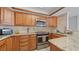 Well-lit kitchen featuring granite countertops, stainless steel appliances, and wood cabinets at 500 Treasure Island Cswy # 704, Treasure Island, FL 33706