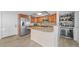 A bright kitchen with stone counters, wooden cabinets, and stainless steel appliances at 500 Treasure Island Cswy # 704, Treasure Island, FL 33706