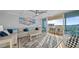 Open-concept living room with beach decor, modern ceiling fan, and sliding glass doors to balcony at 500 Treasure Island Cswy # 704, Treasure Island, FL 33706