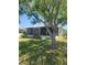 Charming home exterior featuring a screened-in porch and a mature shade tree at 5105 Bonito Dr, New Port Richey, FL 34652
