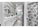 Modern bathroom featuring dual sinks, white cabinets, and a floral shower curtain at 5318 Candler View Dr, Lithia, FL 33547