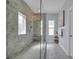 Bathroom featuring a walk-in shower with a glass door, gray tiles, and white marble floors at 5910 Caldera Ridge Dr, Lithia, FL 33547
