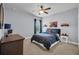 Bedroom with a ceiling fan, a dark blue bed, and a view of the window at 5910 Caldera Ridge Dr, Lithia, FL 33547
