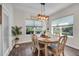 Dining room with hardwood floors, pendant lighting, large windows with wood blinds, and seating for six at 5910 Caldera Ridge Dr, Lithia, FL 33547