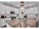 Kitchen featuring a granite countertop, white cabinets, stainless appliances, and pendant lighting over the island at 5910 Caldera Ridge Dr, Lithia, FL 33547