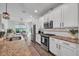 Spacious kitchen area with granite countertops, stainless appliances, white cabinets, and an eat-in dining area at 5910 Caldera Ridge Dr, Lithia, FL 33547