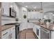 Bright kitchen featuring a granite countertop, white cabinets, stainless appliances, and a subway tile backsplash at 5910 Caldera Ridge Dr, Lithia, FL 33547