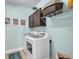 Well-lit laundry room with a washer, dryer, cabinets, and decorative wall art at 5910 Caldera Ridge Dr, Lithia, FL 33547