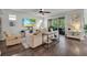 Bright living room with wood floors, a ceiling fan, modern furniture, and sliding glass doors to the outside at 5910 Caldera Ridge Dr, Lithia, FL 33547