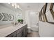 Bathroom features modern vanity, tiled shower, and a stylish decorative mirror at 5953 Bluestar Ct, Lakewood Ranch, FL 34211