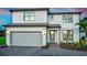 Charming two-story home with white siding, a gray roof, an attached garage, and landscaped yard at 5953 Bluestar Ct, Lakewood Ranch, FL 34211