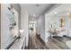 Hallway with gray wood floors leads to a bright room with a desk and artwork at 5953 Bluestar Ct, Lakewood Ranch, FL 34211