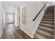 Hallway featuring wood floors, a staircase with a dark banister, and a front door at 5953 Bluestar Ct, Lakewood Ranch, FL 34211