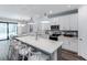 Open-concept kitchen with white cabinets, stainless steel appliances, an island with seating, and modern pendant lighting at 5953 Bluestar Ct, Lakewood Ranch, FL 34211