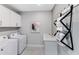 Well-lit laundry room featuring a modern washer, dryer, storage cabinets, and a unique towel rack at 5953 Bluestar Ct, Lakewood Ranch, FL 34211