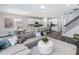 Open-concept living area with a gray sectional sofa, a modern area rug, and a view into the kitchen and dining area at 5953 Bluestar Ct, Lakewood Ranch, FL 34211