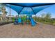 A colorful blue and green playground with slide and play equipment under a shaded canopy at 5953 Bluestar Ct, Lakewood Ranch, FL 34211