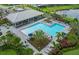 A luxurious community pool with lounge chairs, umbrellas, and lush landscaping creating a serene atmosphere at 5953 Bluestar Ct, Lakewood Ranch, FL 34211