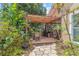 Inviting backyard patio with a pergola, beautiful landscaping, and a stone pathway leading to a cozy outdoor space at 6407 E 112Th Ave, Temple Terrace, FL 33617