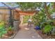 Backyard patio featuring lush greenery, a wooden walkway, and a charming pergola, creating a serene outdoor space at 6407 E 112Th Ave, Temple Terrace, FL 33617