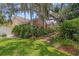 Landscaped front yard featuring a lush lawn and tropical plants around a one-story house at 6407 E 112Th Ave, Temple Terrace, FL 33617