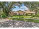 Inviting one-story home with a sprawling front lawn framed by mature trees and verdant landscaping at 6407 E 112Th Ave, Temple Terrace, FL 33617