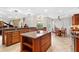 Spacious kitchen featuring custom wood cabinets, a center island, and an adjacent breakfast nook at 6407 E 112Th Ave, Temple Terrace, FL 33617