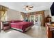 Bright main bedroom featuring French door access to a pool, tile flooring, and an en-suite bathroom at 6407 E 112Th Ave, Temple Terrace, FL 33617